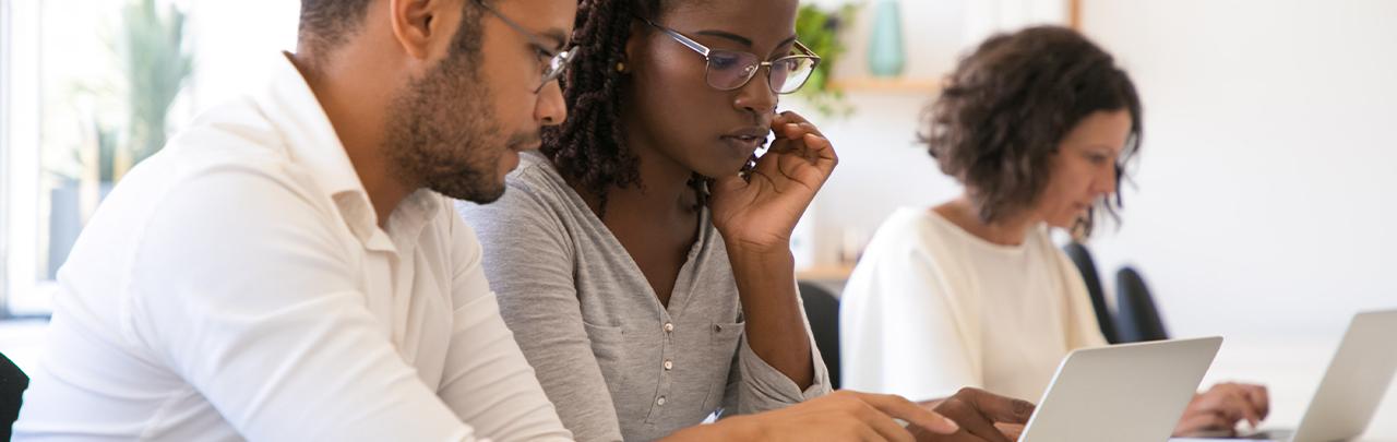 Two people seated using a laptop computer