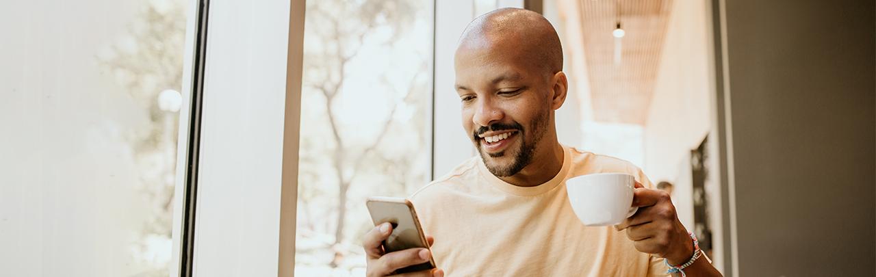 Man viewing his phone in a coffee shop