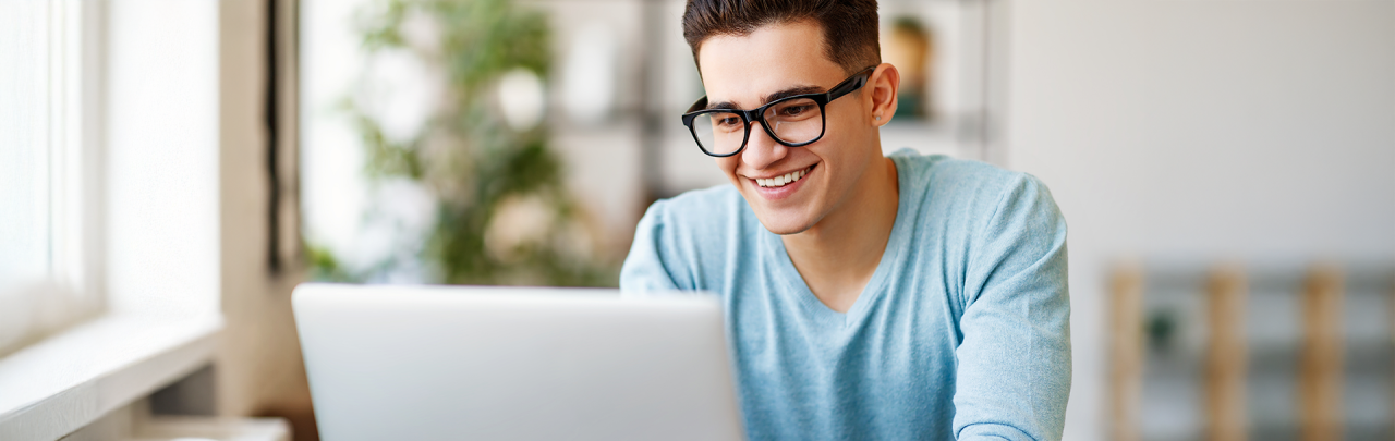 Young man sitting down using a laptop computer