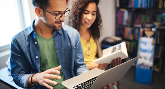 Two students working on a laptop
