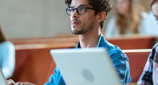 Students learning on laptop in classroom