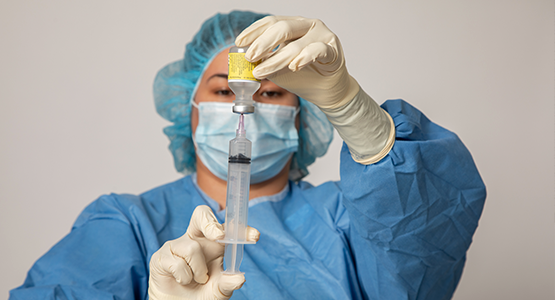 Woman using a syringe in full garb