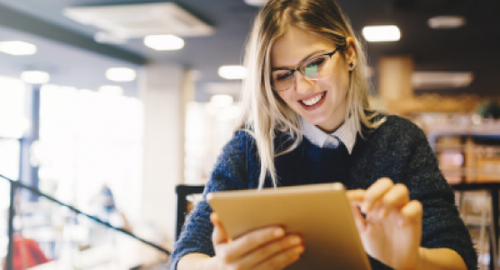 Woman standing while using a tablet in a library