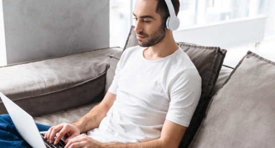 Man using a laptop while wearing headphones