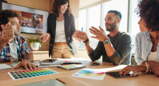 Four people in a meeting seated around a table talking