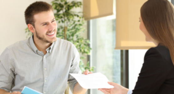 Man handing his resume to a woman